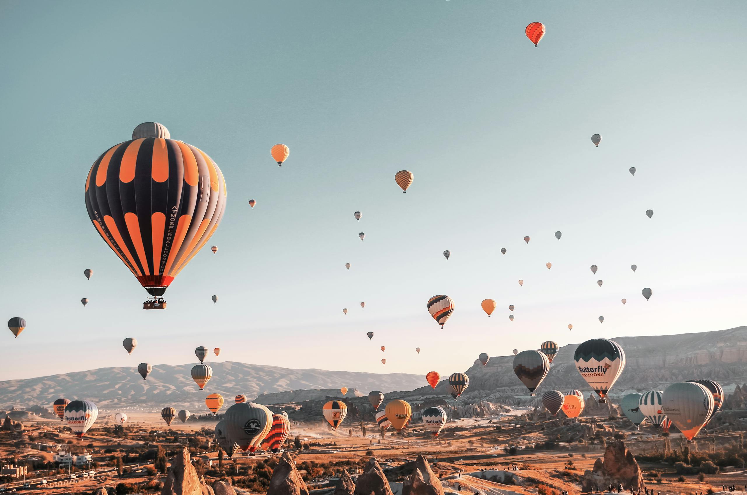 A stunning view of hot air balloons filling the sky over Cappadocia, Turkey at sunrise.